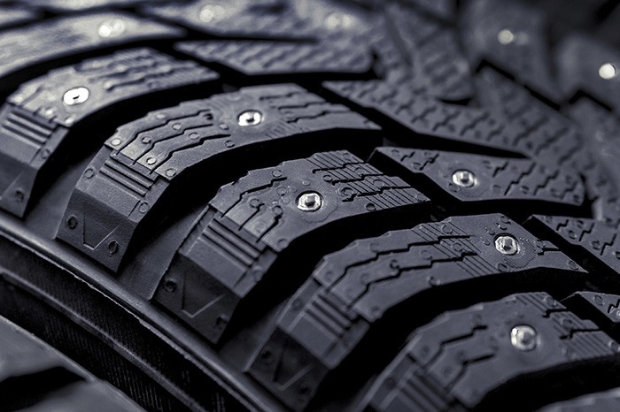 Winter tires for the car. Radial tread, thin lamellas and metal spikes. Photo en gros plan d'un pneu clouté